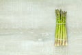 Asparagus sprouts on light wooden surface.