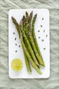 Asparagus stems on the white plate served with green lemon and cut chives Royalty Free Stock Photo