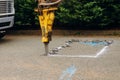 Large jackhammer crushing asphalt paving during road construction works