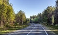 Asphalt highway with road markings through a coniferous forest Royalty Free Stock Photo