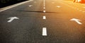 Asphalt highway with road markings. Road and orange sunlight background. Royalty Free Stock Photo