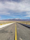 Asphalt highway stretching towards snow mountain Royalty Free Stock Photo