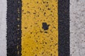 Asphalt highway texture with cracked white and yellow stripe