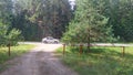 From the asphalt highway into the woods departing dirt road. The metal barrier at the entrance to the forest is open. It is closed