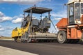 Asphalt laying equipment. Work on the device of a new road surface in a modern city. Powerful construction equipment for Royalty Free Stock Photo