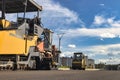 Asphalt laying equipment. Work on the device of a new road surface in a modern city. Powerful construction equipment for Royalty Free Stock Photo