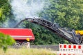 Asphalt milling and grinding machine at road repair and construction site throwing shredded old bitumen in big Royalty Free Stock Photo