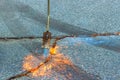 An asphalt patcher performs restoration work in cracks of road surface by burning dry grass before applying a coating of Royalty Free Stock Photo
