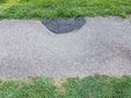 Asphalt path with damaged and fixed section and grass Royalty Free Stock Photo