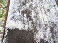 Asphalt path partially cleared of ice in city park