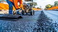 Asphalt paver machine laying fresh asphalt on the surface of a newly constructed road