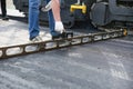 road worker checks the level of paving the roadway