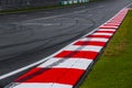 Asphalt red and white kerb of a race track detail with tire marks Royalty Free Stock Photo