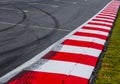 Asphalt red and white kerb of a race track detail with tire marks Royalty Free Stock Photo