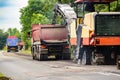 Asphalt removing machine loading powdered asphalt on the truck Royalty Free Stock Photo