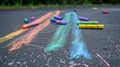 Colorful chalks on asphalt with the image of an arrow.