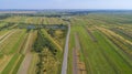 Asphalt road through agricultural fields. Fall time. aerial view