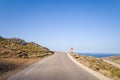 An asphalt road in the arid countryside and mountains , in Europe, Greece, Crete, towards Elafonisi, By the Mediterranean Sea, in Royalty Free Stock Photo