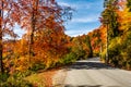 Asphalt road through autumn forest in mountains Royalty Free Stock Photo