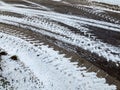 Asphalt road background with crossing of snowy tires imprints