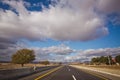 Asphalt road and bright blue sky with fluffy clouds . Empty desert asphalt road from low angle with mountains and clouds on Royalty Free Stock Photo