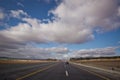 Asphalt road and bright blue sky with fluffy clouds . Empty desert asphalt road from low angle with mountains and clouds on Royalty Free Stock Photo