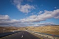 Asphalt road and bright blue sky with fluffy clouds . Empty desert asphalt road from low angle with mountains and clouds on Royalty Free Stock Photo