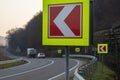 Asphalt road with bright traffic signs in situ of the sharp left turn