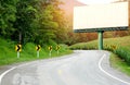 Asphalt road curved side of a cornfield with arrow signs,Big white billboard on the curve. Royalty Free Stock Photo