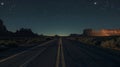 Asphalt road in the desert at night, moonlit with shrubs and rock formations under a starry sky Royalty Free Stock Photo