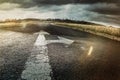 asphalt road with direction arrows straight ahead and right in sunshine and natural landscape Royalty Free Stock Photo