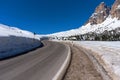 Asphalt road in the Dolomites in the spring. Mountains and forests against a blue sky