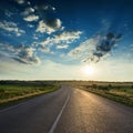 Asphalt road and dramatic clouds in dark sky in sunset Royalty Free Stock Photo