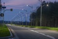 Asphalt road in the evening light, illuminated with the light of street lanterns.