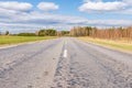 Asphalt road field and forest sunny white cloud blue sky shot Royalty Free Stock Photo