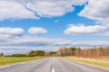 Asphalt road field and forest sunny white cloud blue sky shot Royalty Free Stock Photo