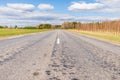 Asphalt road field and forest sunny white cloud blue sky shot Royalty Free Stock Photo