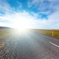 Asphalt Road field landscape with the bright solar effect Royalty Free Stock Photo