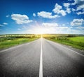 Asphalt road in field under blue sky Royalty Free Stock Photo