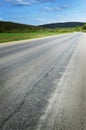 Asphalt road goes into the distance and disappears into the woods