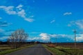 Asphalt road among the green field, blue sky with white clouds. Spring background horizontal photo, travel concept Royalty Free Stock Photo