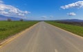 Asphalt road between green fields Royalty Free Stock Photo