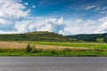 Asphalt road, green meadow , agricultural fields with blue sky with white clouds Royalty Free Stock Photo