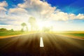 Asphalt road in green meadow. Sunset Royalty Free Stock Photo