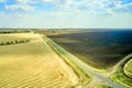 asphalt road between harvested wheat field and arable land on the background of blue sky with clouds rural landscape Royalty Free Stock Photo