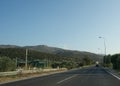 An asphalt road in the island Thasos, cars, beautiful nature and mountain in the background, vacation and transportation concept