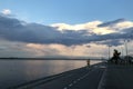 Asphalt road for jogging near lake, mans` silhouete running,