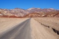 Asphalt road leading through steaming hot landscape of Death Valley National Park, California, USA. Super hot sunny day Royalty Free Stock Photo