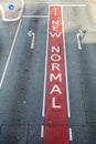 Asphalt road with marked lanes and directional arrows, text New Normal, coronavirus pandemic concept, selected focus