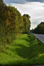 Asphalt road among meadows and trees on a sunny autumn day. Autumn. Sun. Royalty Free Stock Photo